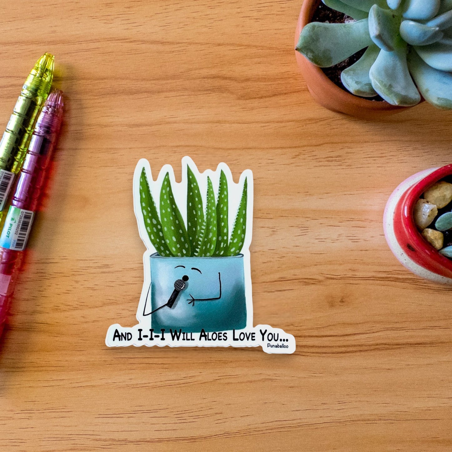 “And I Will Aloes Love You” aloe sticker — hand-drawn plant pun design by Punaballoo, waterproof vinyl decal for plant-lovers and pun collectors.
