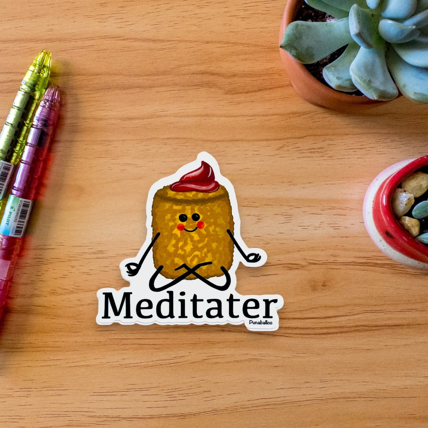 “Meditater” tater tot sticker — hand-drawn food pun design by Punaballoo, waterproof vinyl decal for snack pun lovers and humor fans.