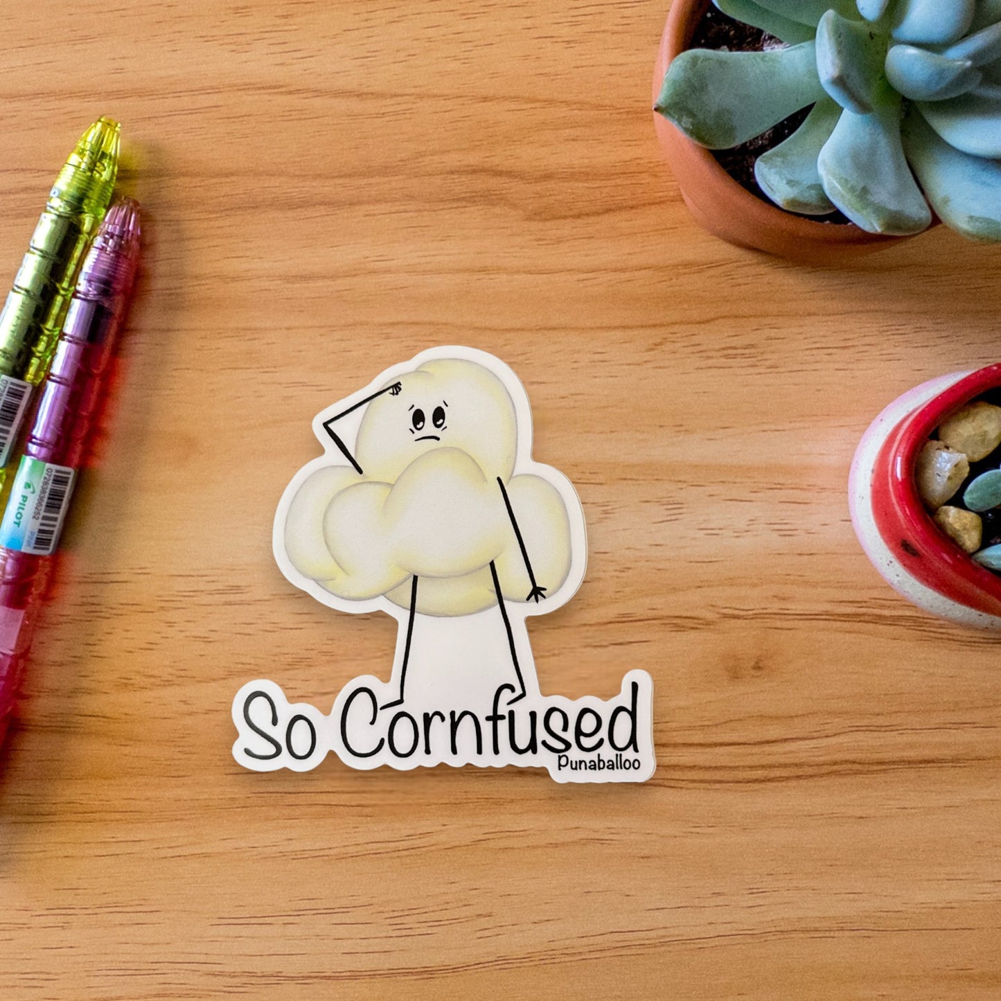 “So Cornfused” popcorn sticker: a funny, hand-drawn pun about brain fog and snack confusion. 🍿 Waterproof vinyl decal for forgetful pun lovers.