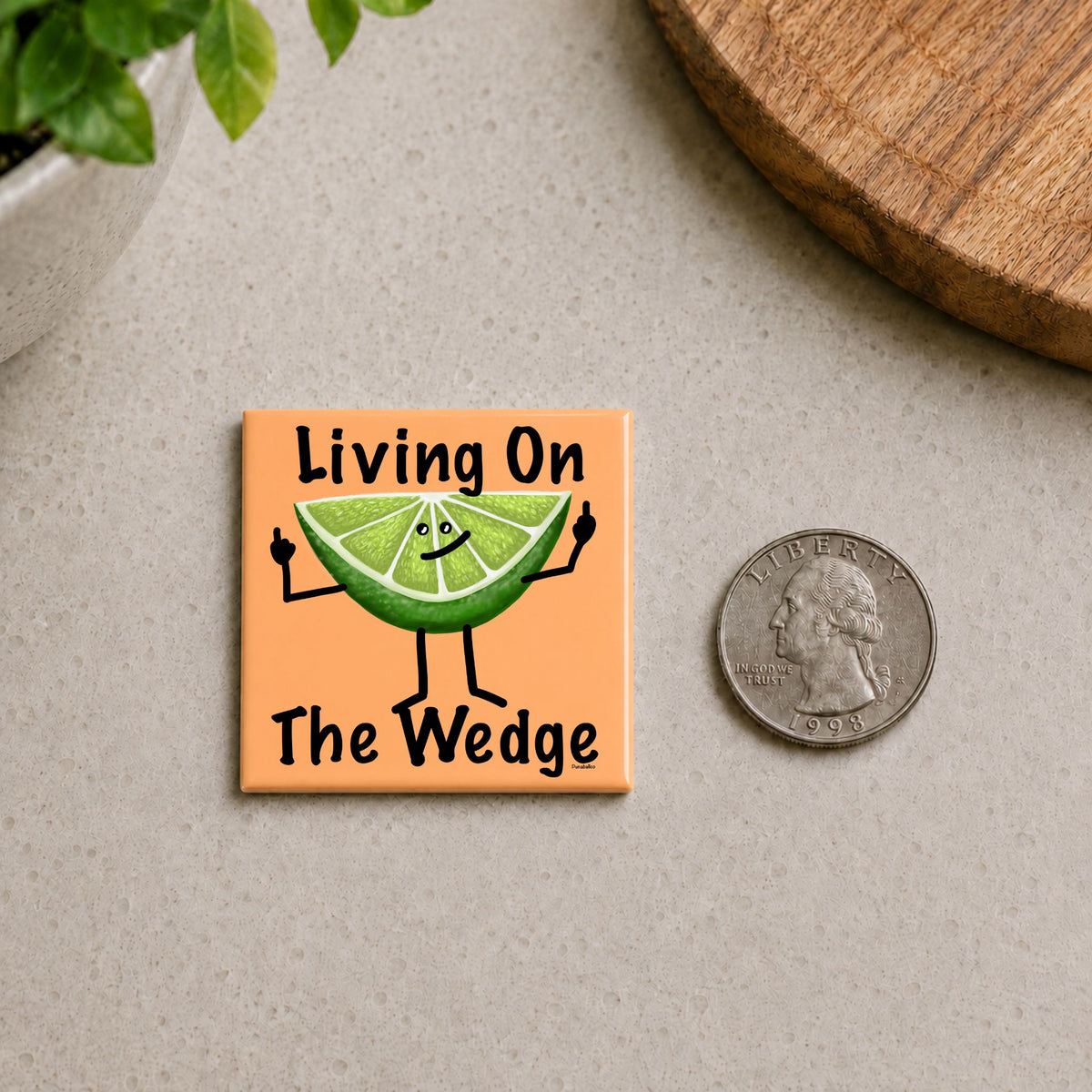 Living on the Wedge lime pun magnet shown beside a quarter for scale