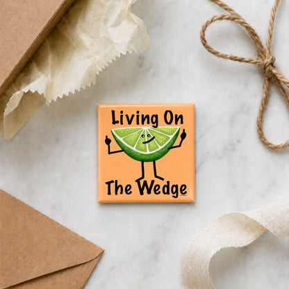 Funny lime magnet arranged with gift wrap, an envelope, ribbon, and twine