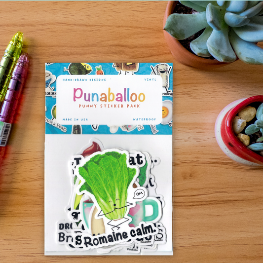 A packaged sticker pack labeled Punaballoo Punny Sticker Pack, placed on a wooden desk with decorative succulent plants and colored pens nearby.