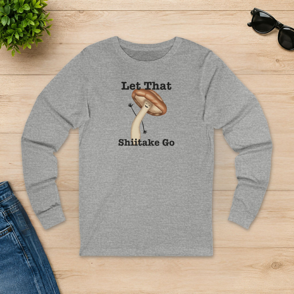 Athletic heather Let That Shiitake Go long sleeve shirt laid flat on a wooden table