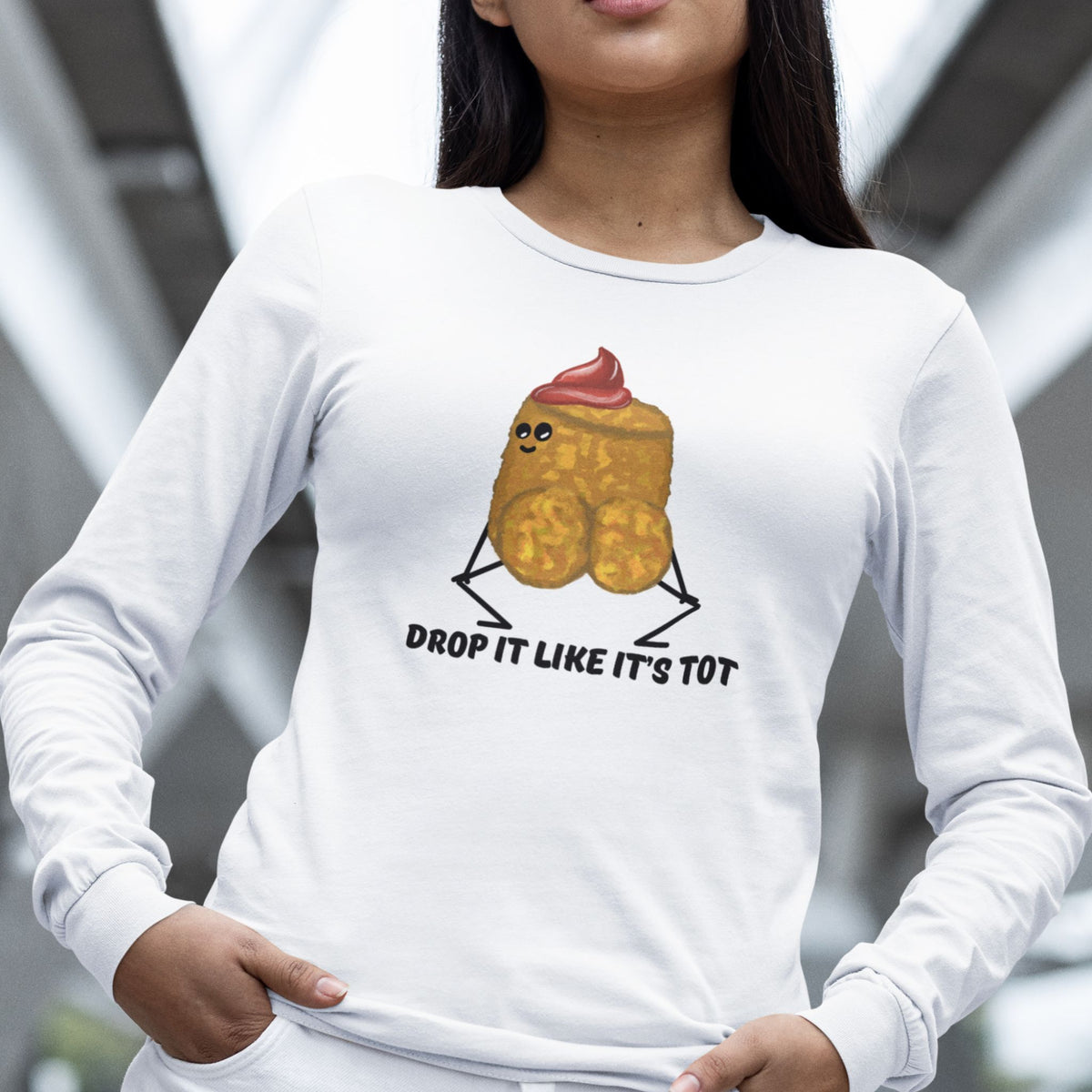 Woman wearing a white Drop It Like It’s Tot funny potato long sleeve T-shirt