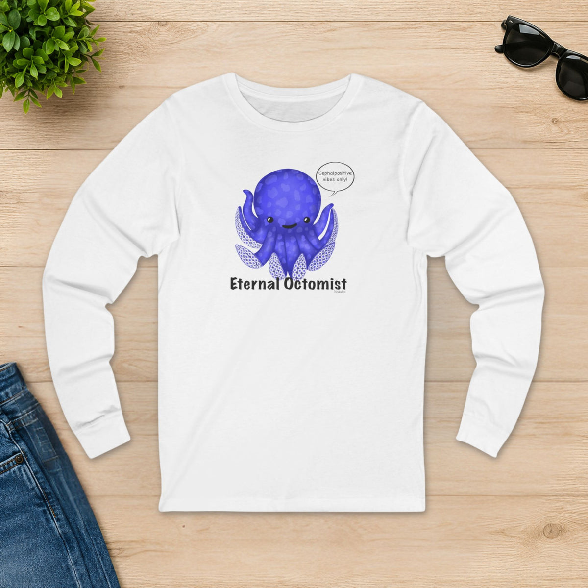 White Eternal Octomist octopus shirt laid flat on a wooden table