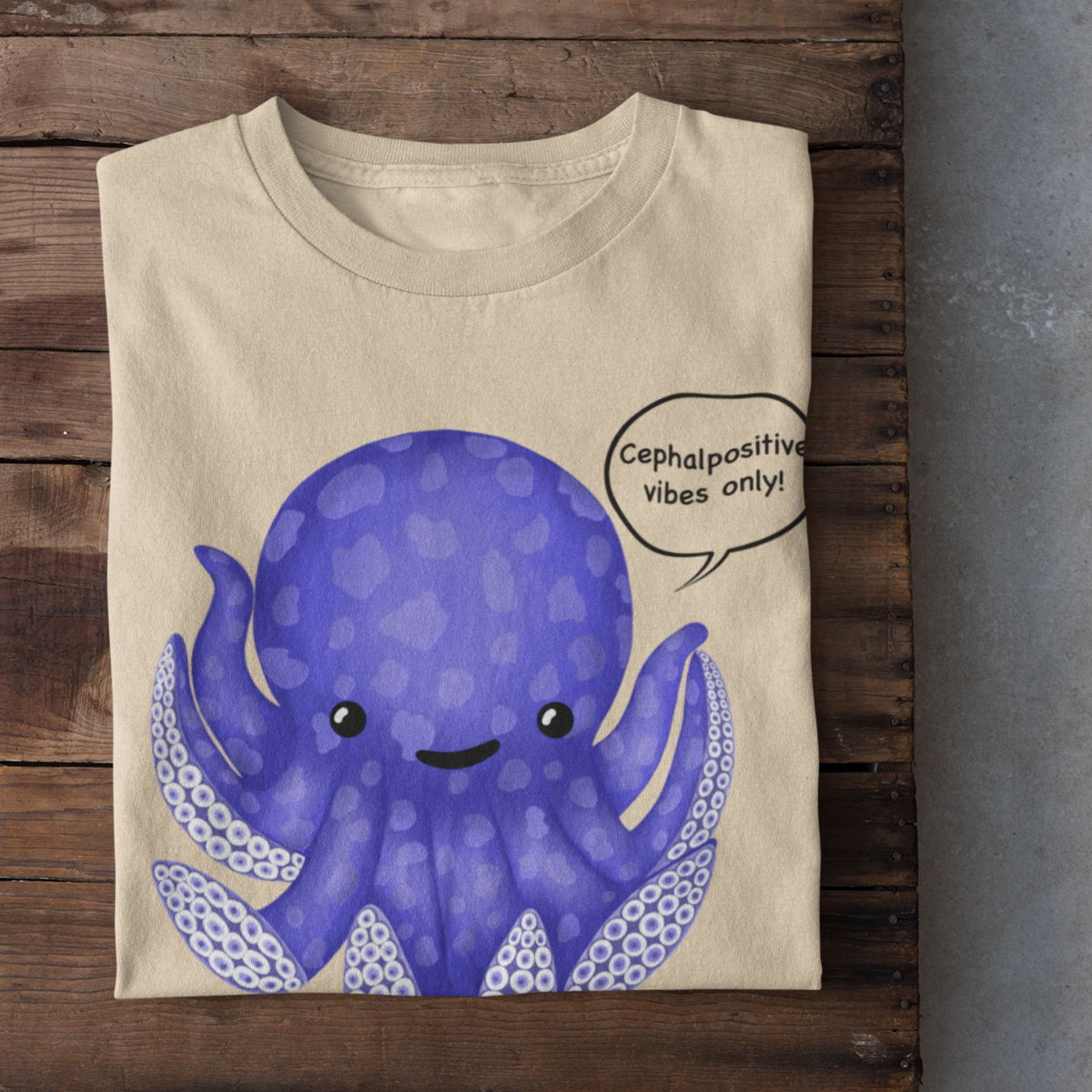 Soft cream T-shirt flat lay featuring the purple Eternal Octomist octopus and Cephalopositive vibes only design.