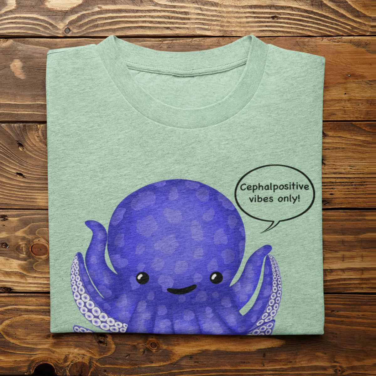 Heather mint T-shirt flat lay featuring the purple Eternal Octomist octopus and Cephalopositive vibes only design.