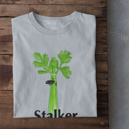 Light blue Stalker celery pun T-shirt flat lay featuring a green celery character holding binoculars.