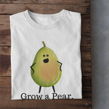 A folded white T-shirt with a cartoon pear character and the text 'Grow a Pear.' displayed on a rustic wooden surface, with white sneakers partially visible at the bottom right.
