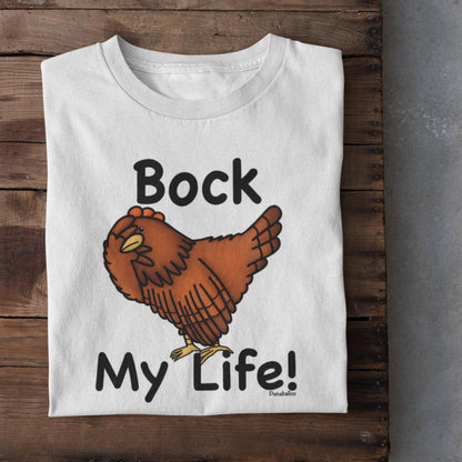White folded Bock My Life poultry pun t-shirt shown on a rustic wooden surface