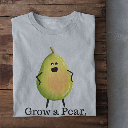 A folded light blue T-shirt with a cartoon pear character and the text 'Grow a Pear.' laid flat on a rustic wooden surface, with white sneakers partially visible at the bottom right.