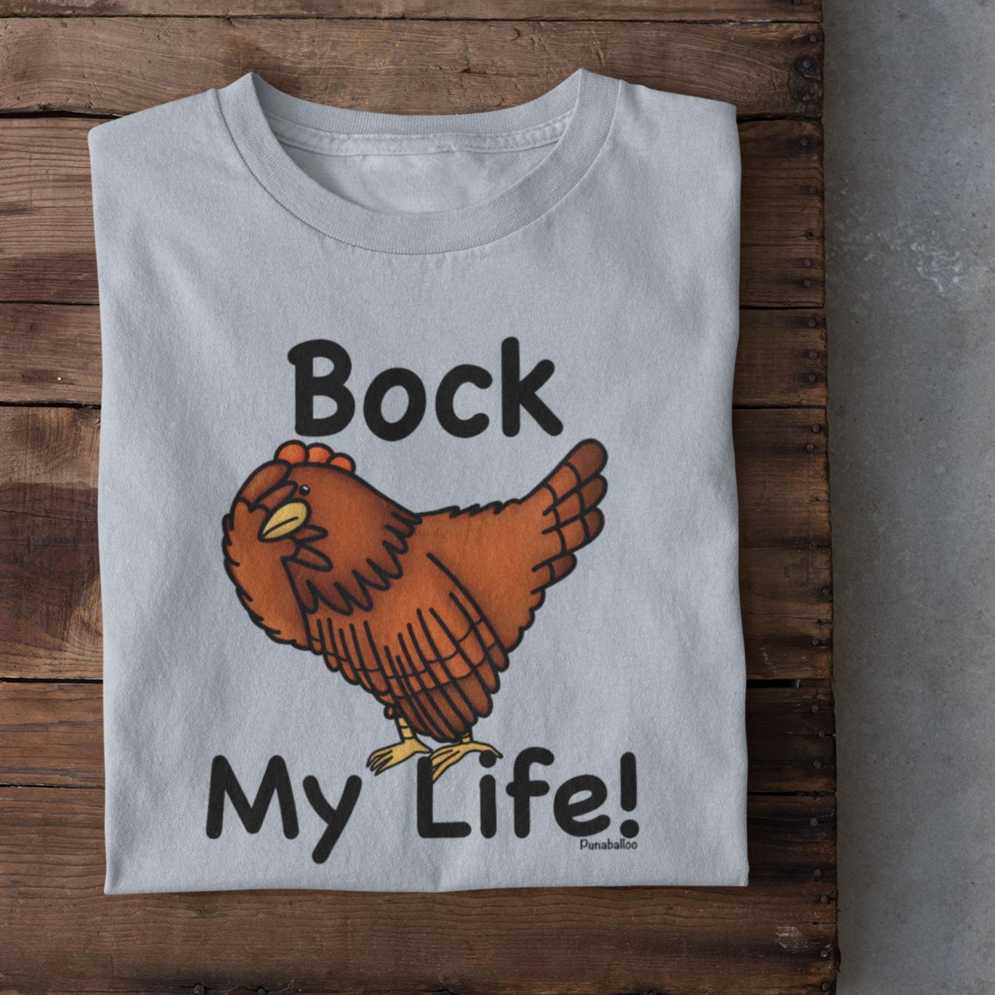 Light Blue folded funny chicken lover t-shirt with Bock My Life pun design on wood background
