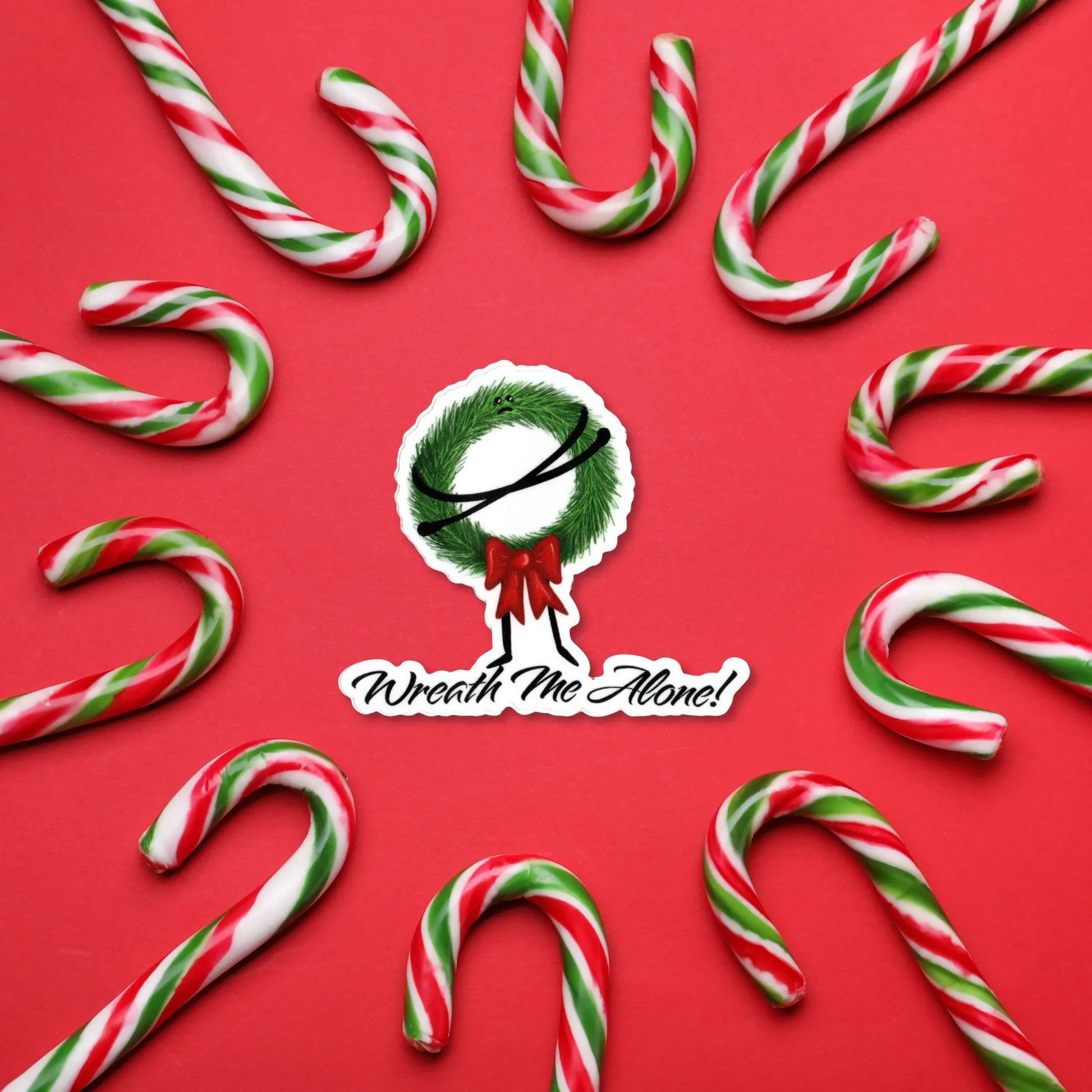 Wreath Me Alone sticker — hand-drawn grumpy Christmas wreath pun design, waterproof vinyl decal.