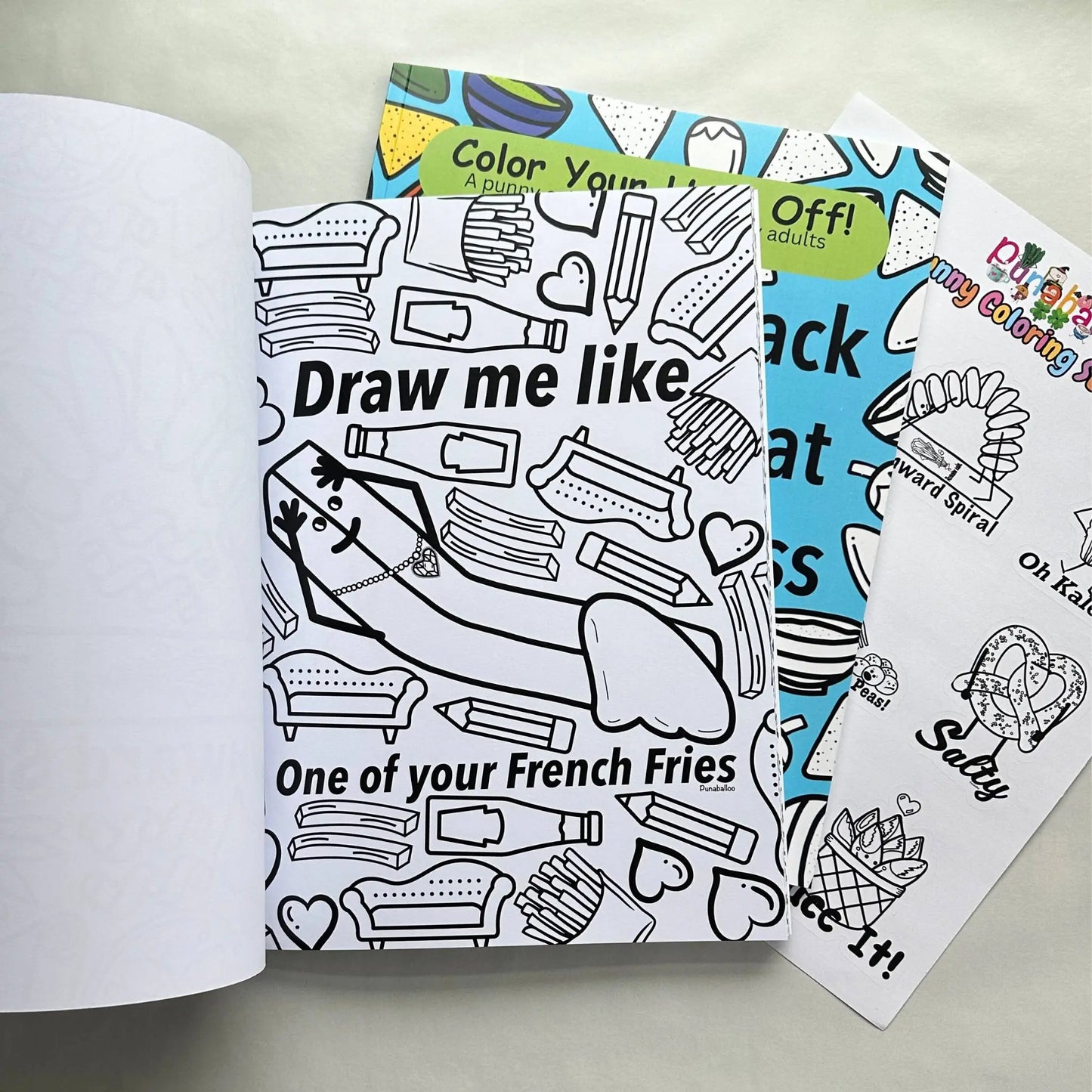 Adult coloring book bundle open to French fries pun coloring page with coordinating sticker sheet