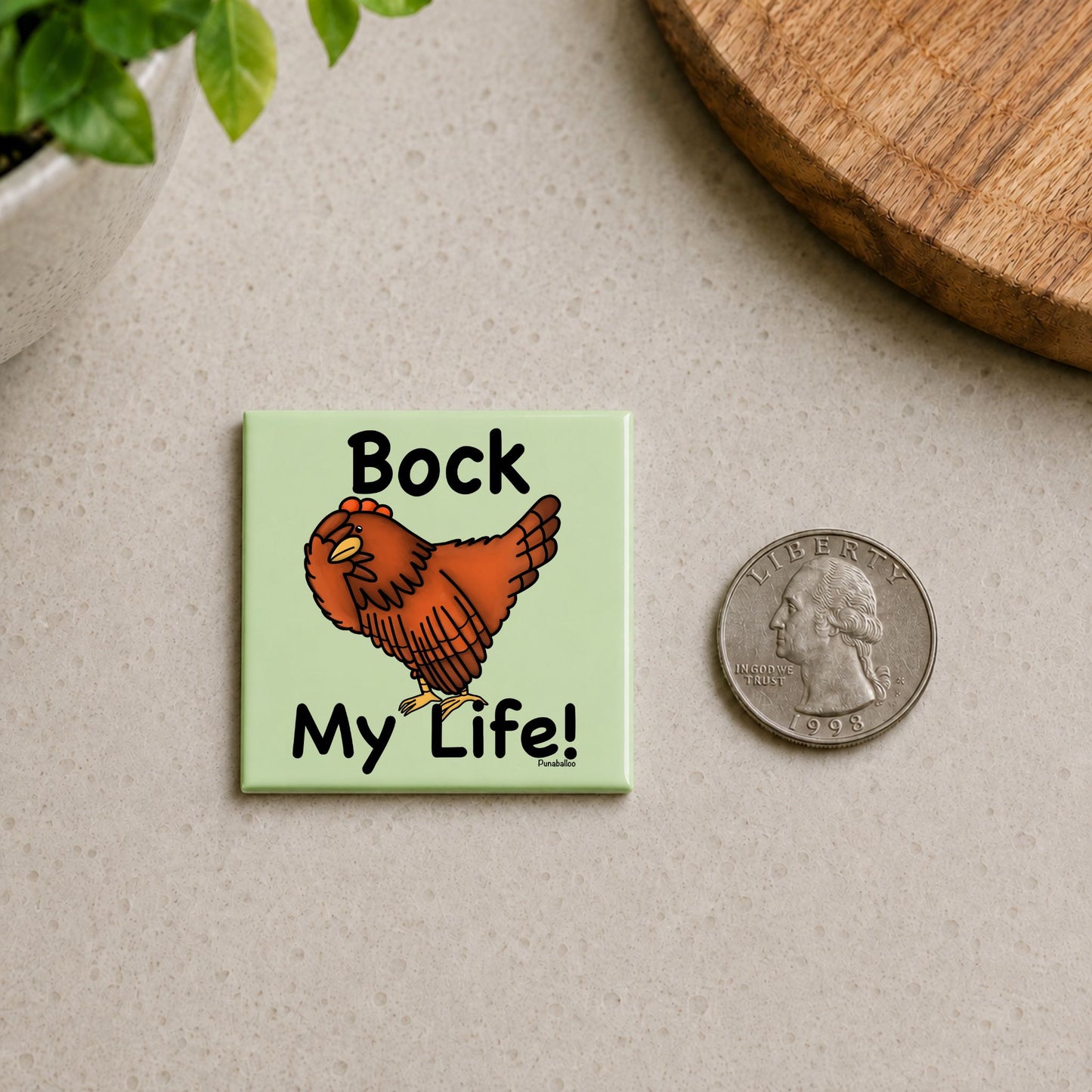 Bock My Life chicken pun magnet on a countertop beside a quarter for size