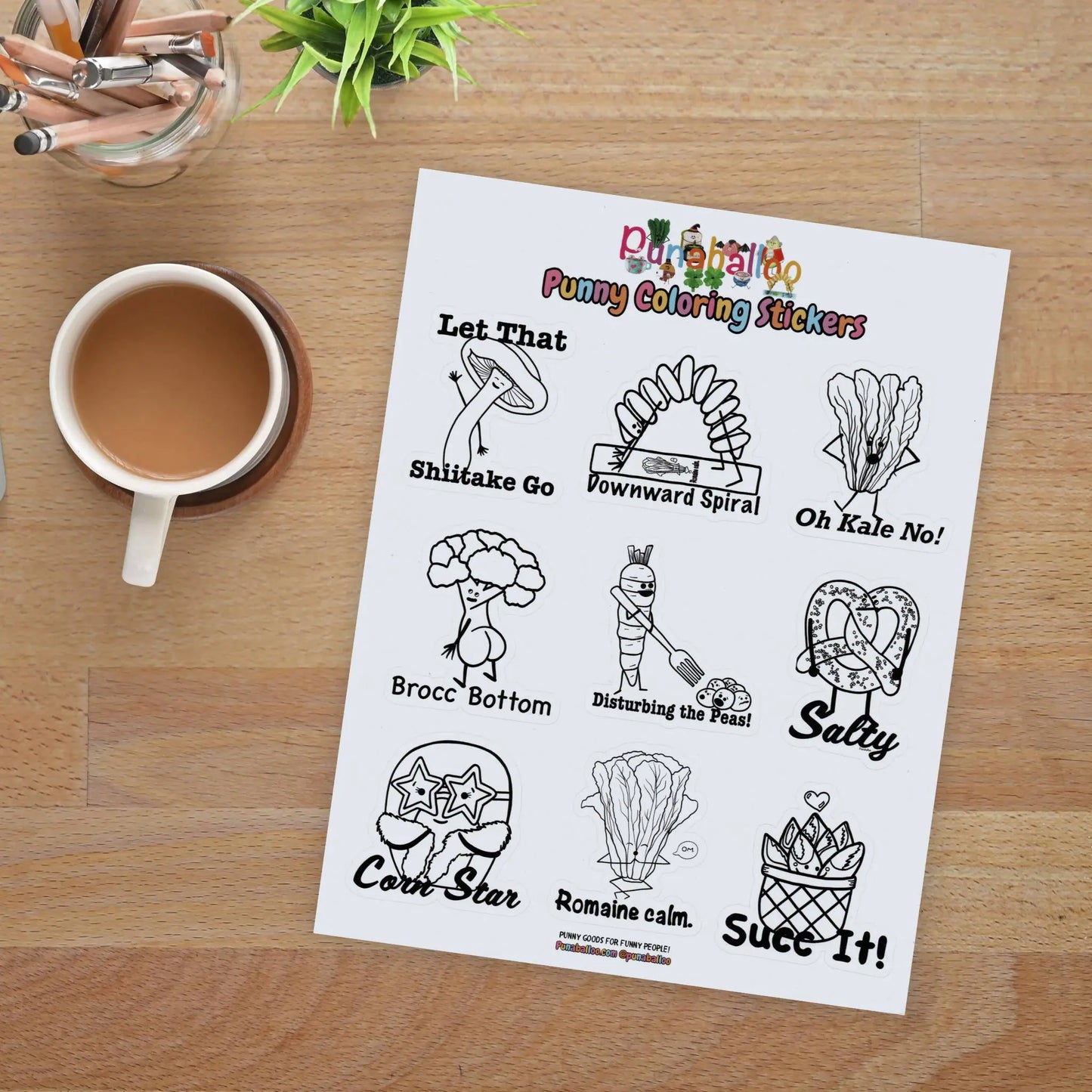 Funny food pun coloring sticker sheet for adults with black and white hand drawn designs on a desk with coffee and pencils