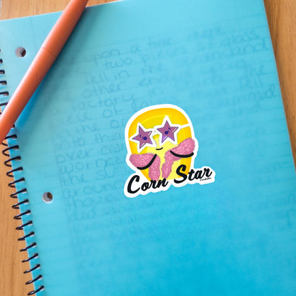 “Corn Star” corn sticker — hand-drawn food pun design by Punaballoo, waterproof vinyl decal for snack lovers and humor fans.