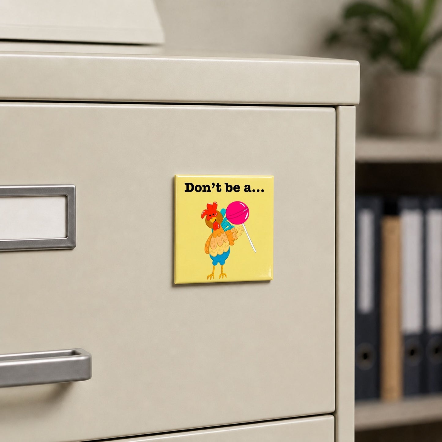 Don’t Be a Cocksucker chicken pun magnet on a cream file cabinet