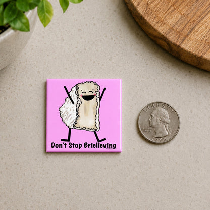 Don’t Stop Brielieving cheese pun magnet on a countertop beside a quarter for size