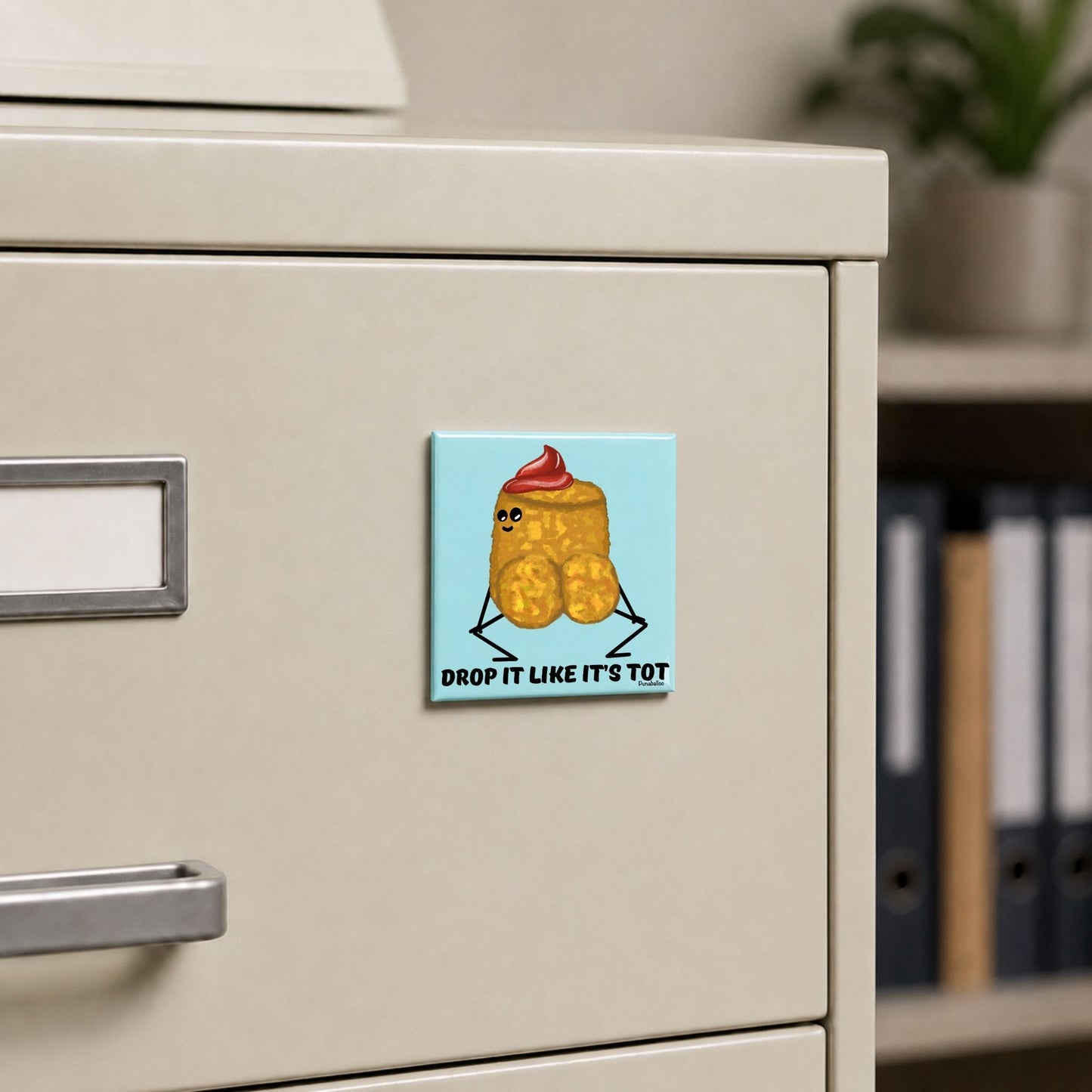 Drop It Like It’s Tot funny potato magnet on a cream file cabinet