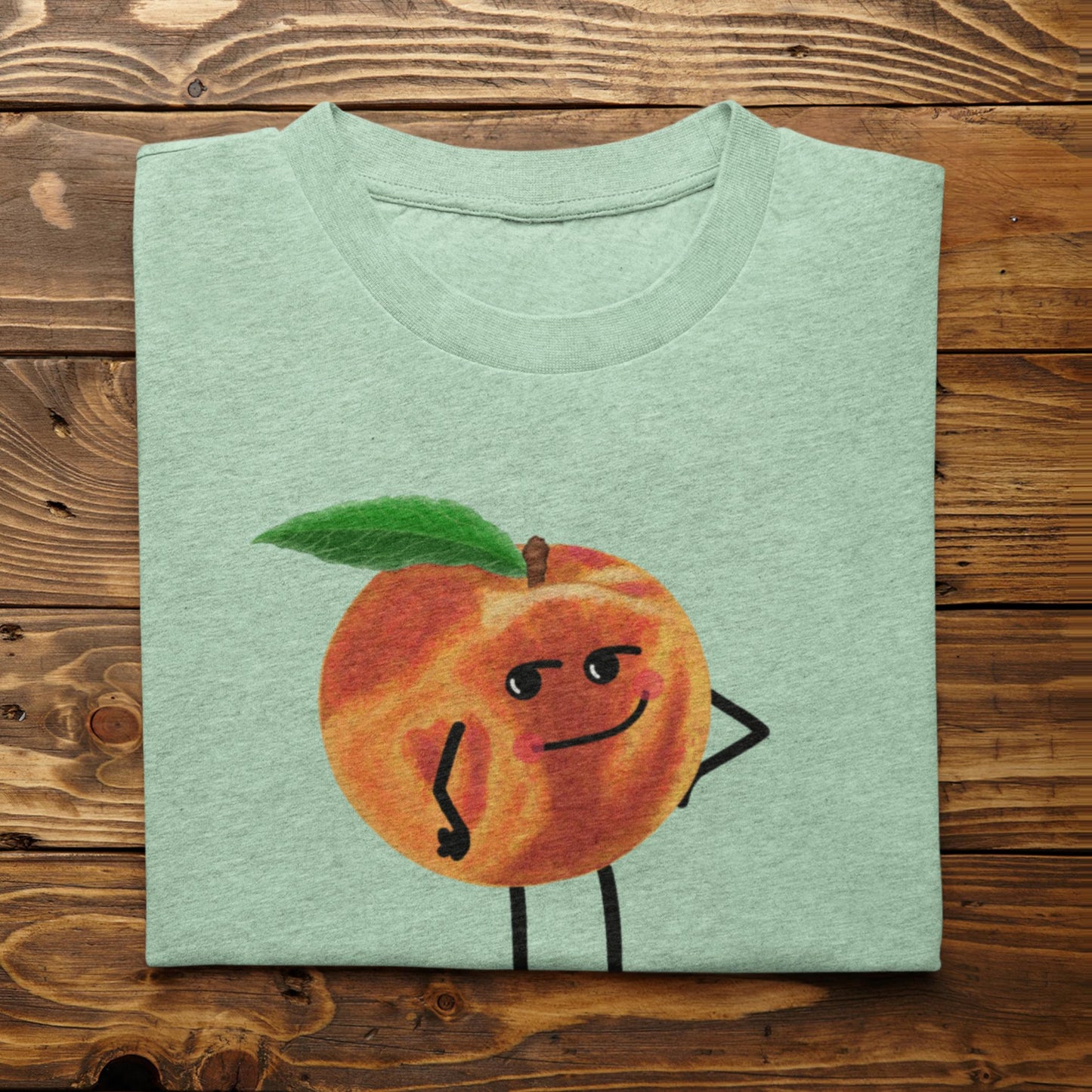 Folded heather mint Karma Is a Peach fruit pun t-shirt on rustic wood background