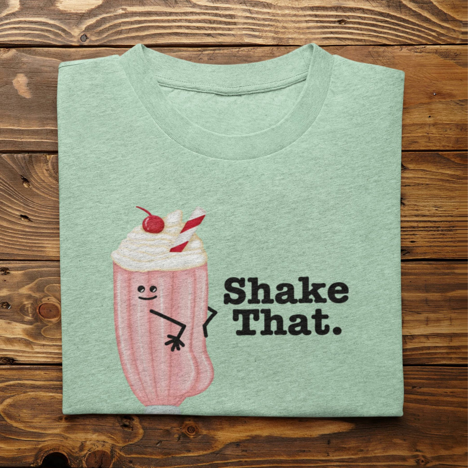 Folded heather mint Shake That ice cream pun t-shirt on rustic wood background