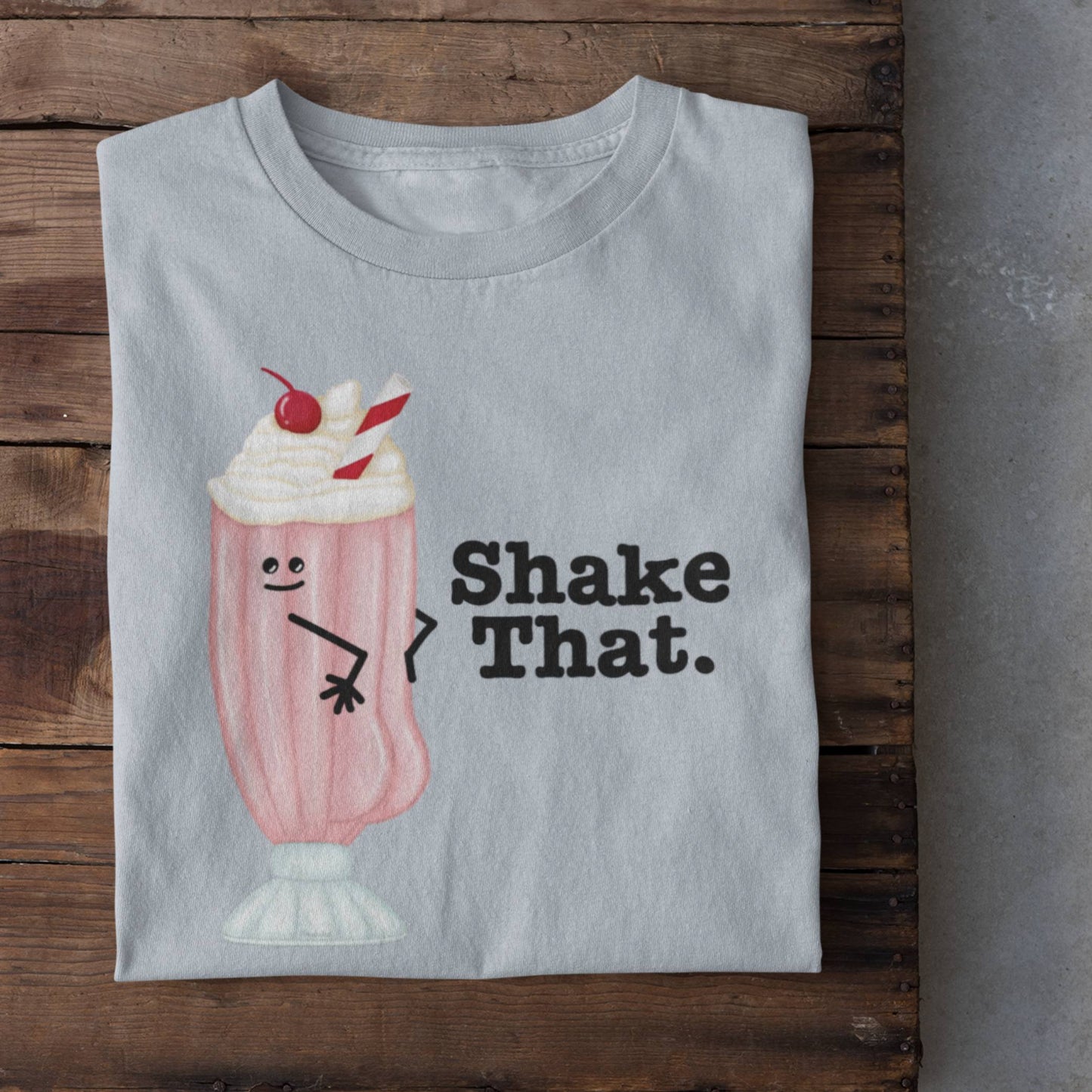 Folded light blue Shake That milkshake t-shirt on rustic wood background
