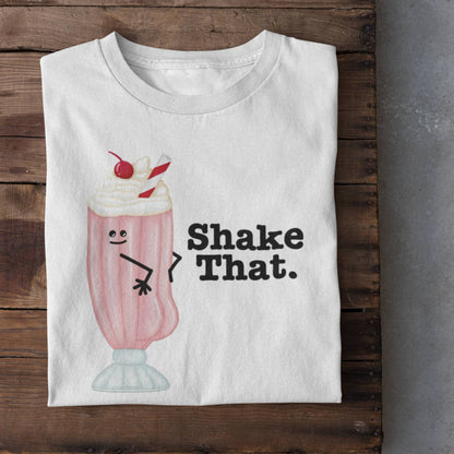Folded white Shake That funny milkshake t-shirt on rustic wood background