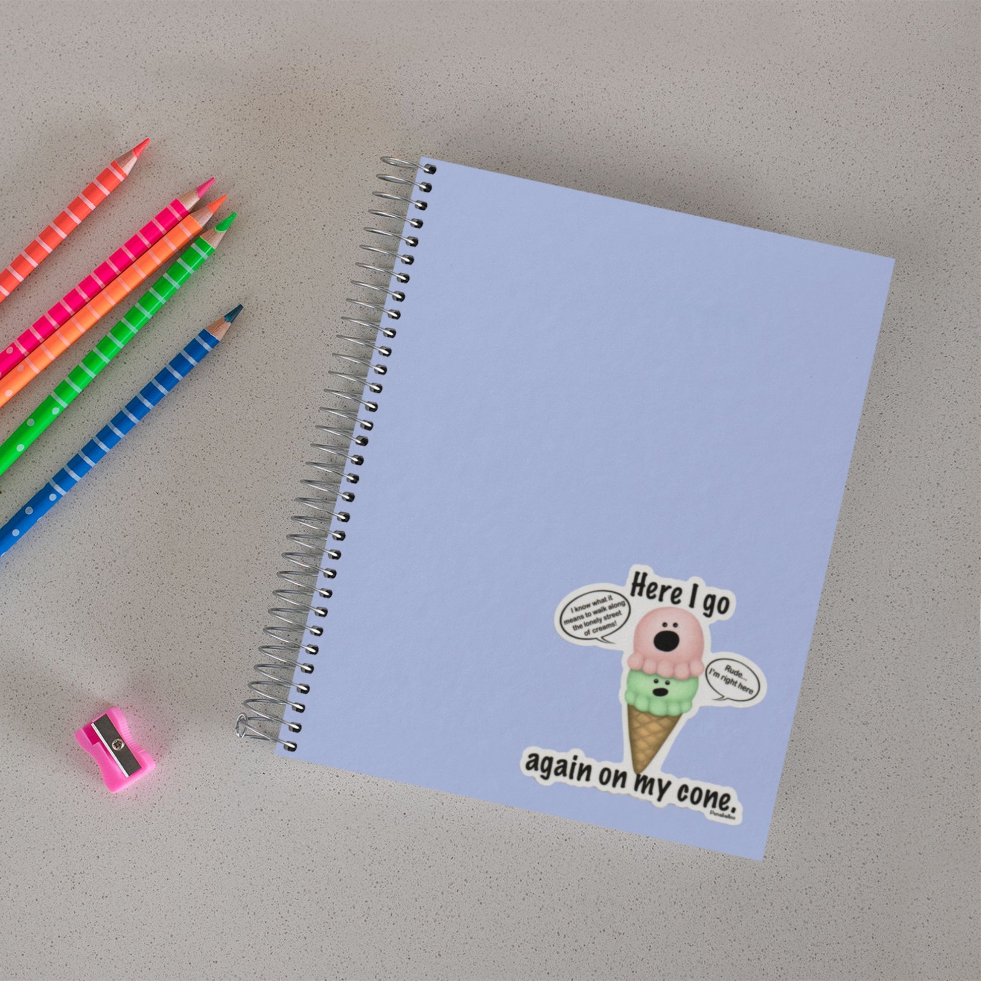 Here I Go Again on My Cone ice cream sticker on a notebook beside colored pencils