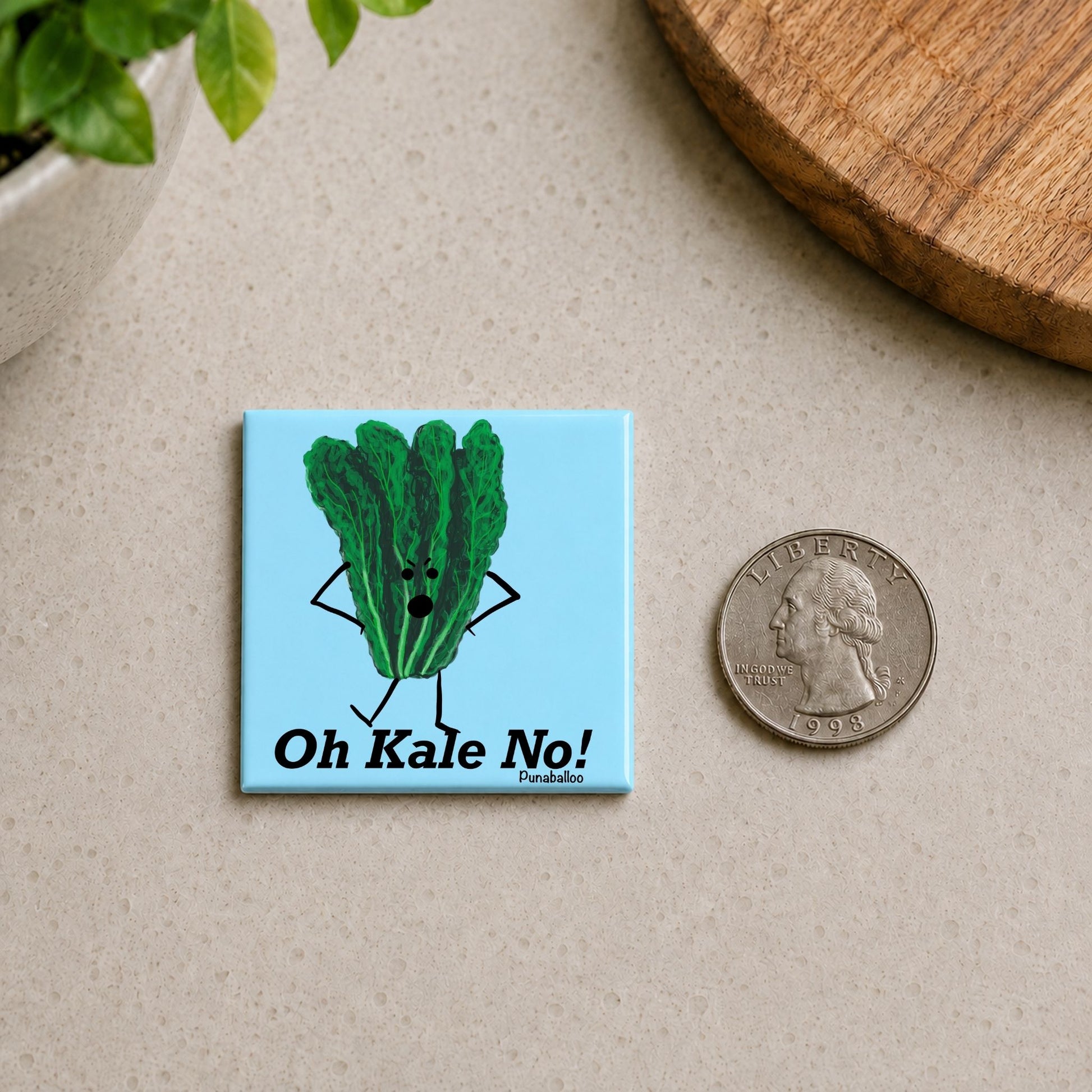 Oh Kale No kale pun magnet on a countertop beside a quarter for size