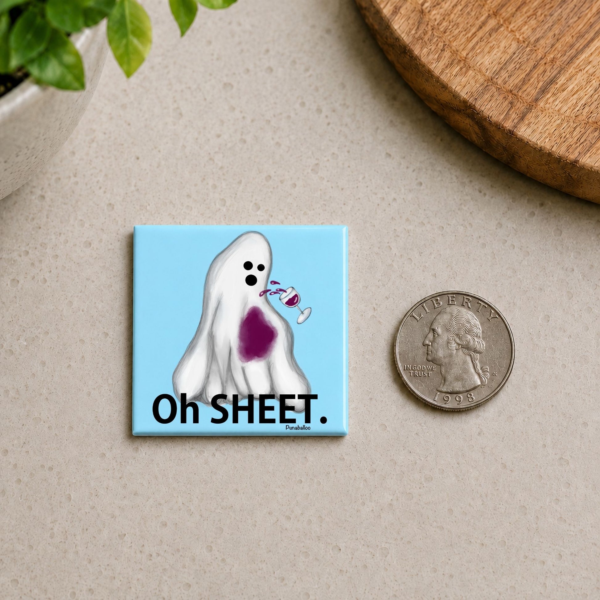 Oh Sheet funny ghost magnet on a countertop beside a quarter for size