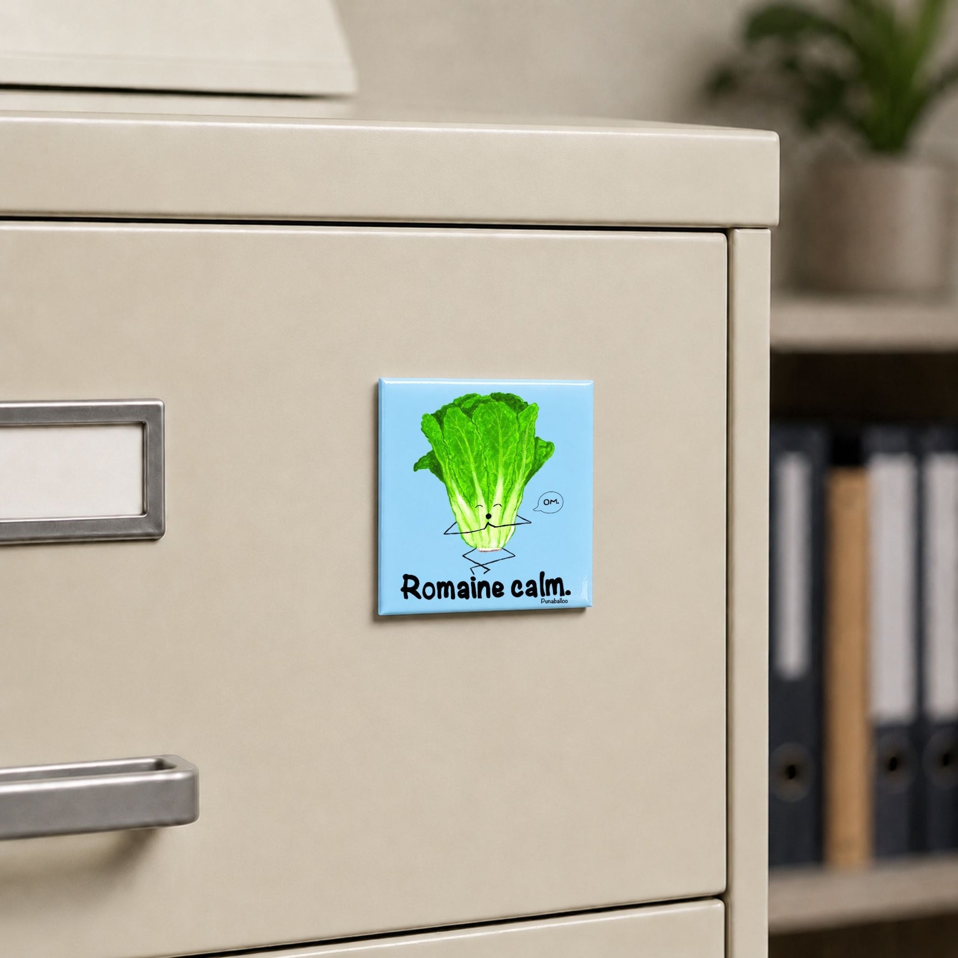 Romaine Calm lettuce pun magnet on a cream file cabinet