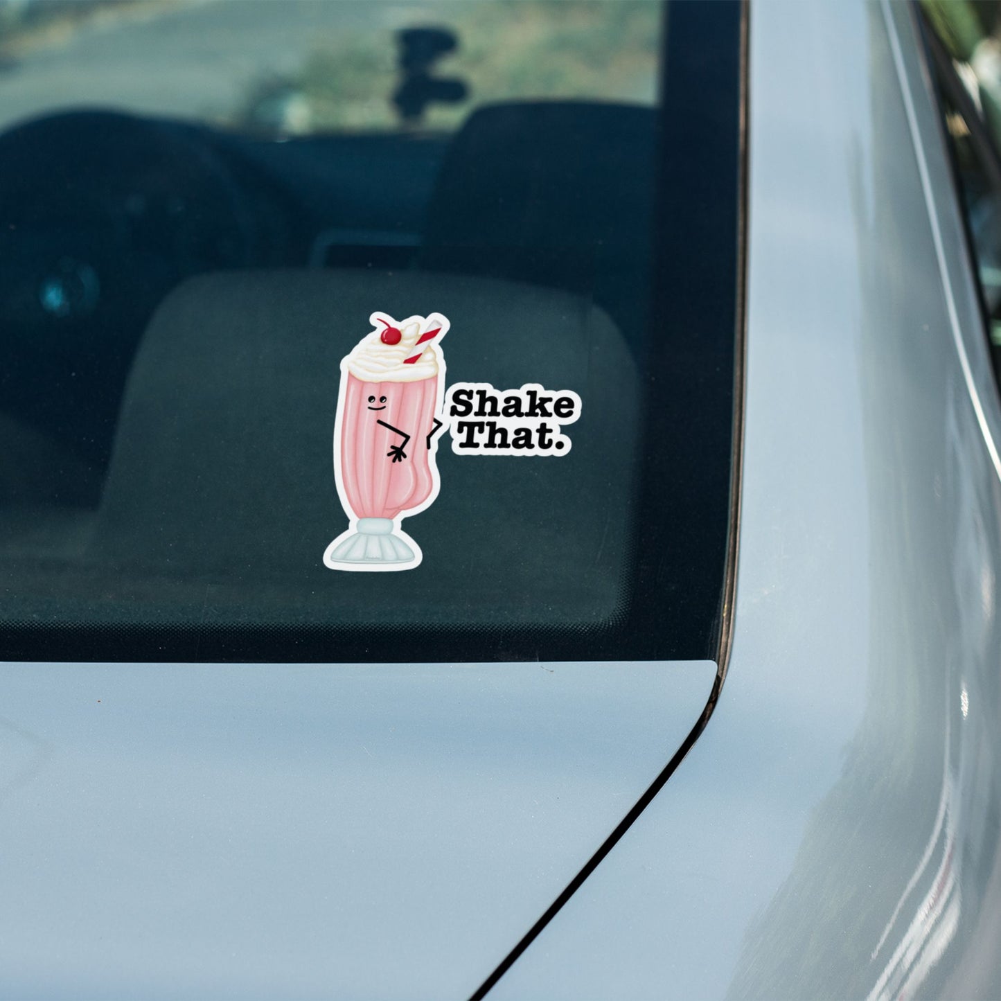 Shake That milkshake pun sticker on a car window