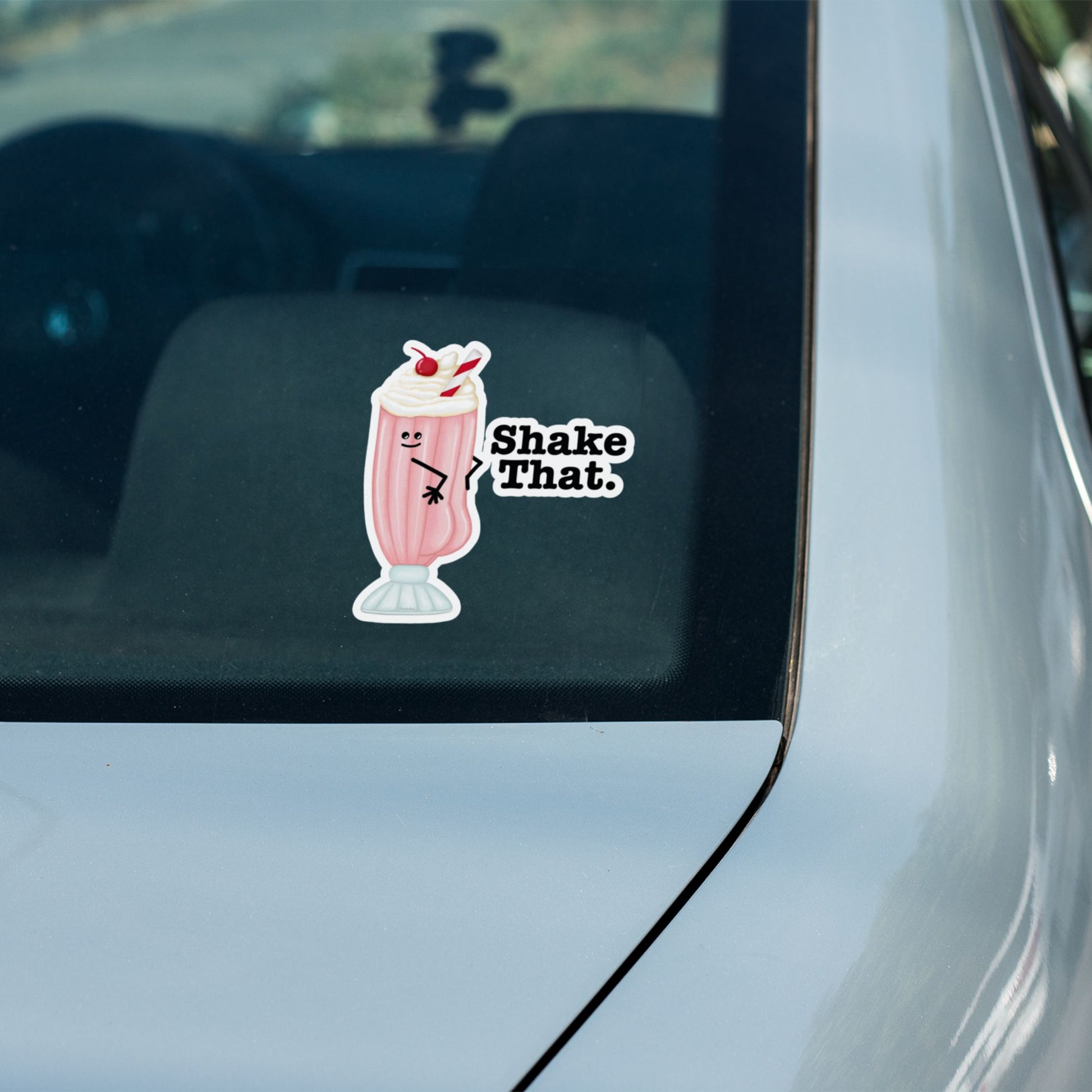 Shake That milkshake pun sticker on a car window