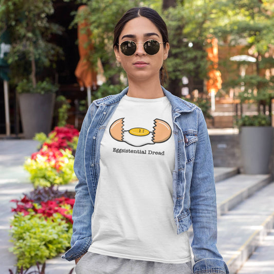 Woman wearing a white Eggsistential Dread egg t-shirt with denim jacket outdoors