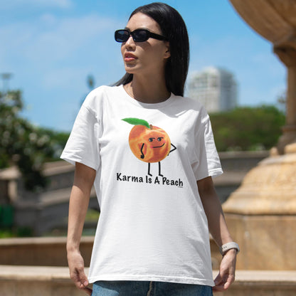Woman in sun glasses wearing a white Karma Is a Peach funny peach t-shirt outdoors