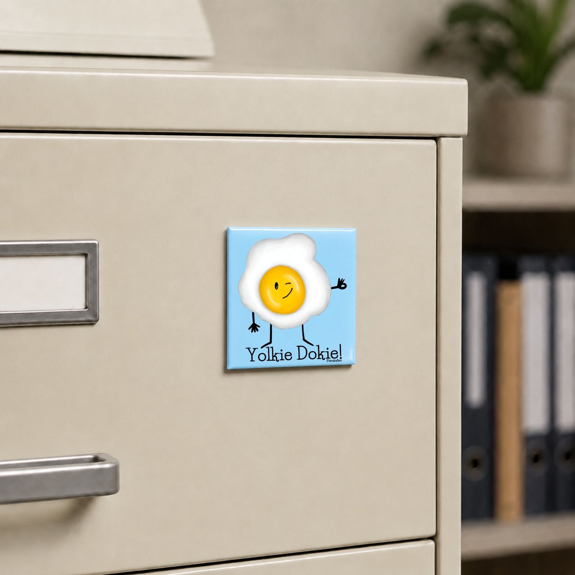 Yolkie Dokie egg pun magnet on a cream file cabinet