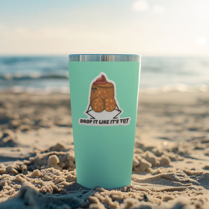 Drop It Like It's Tot tater tot sticker displayed on a mint tumbler at the beach