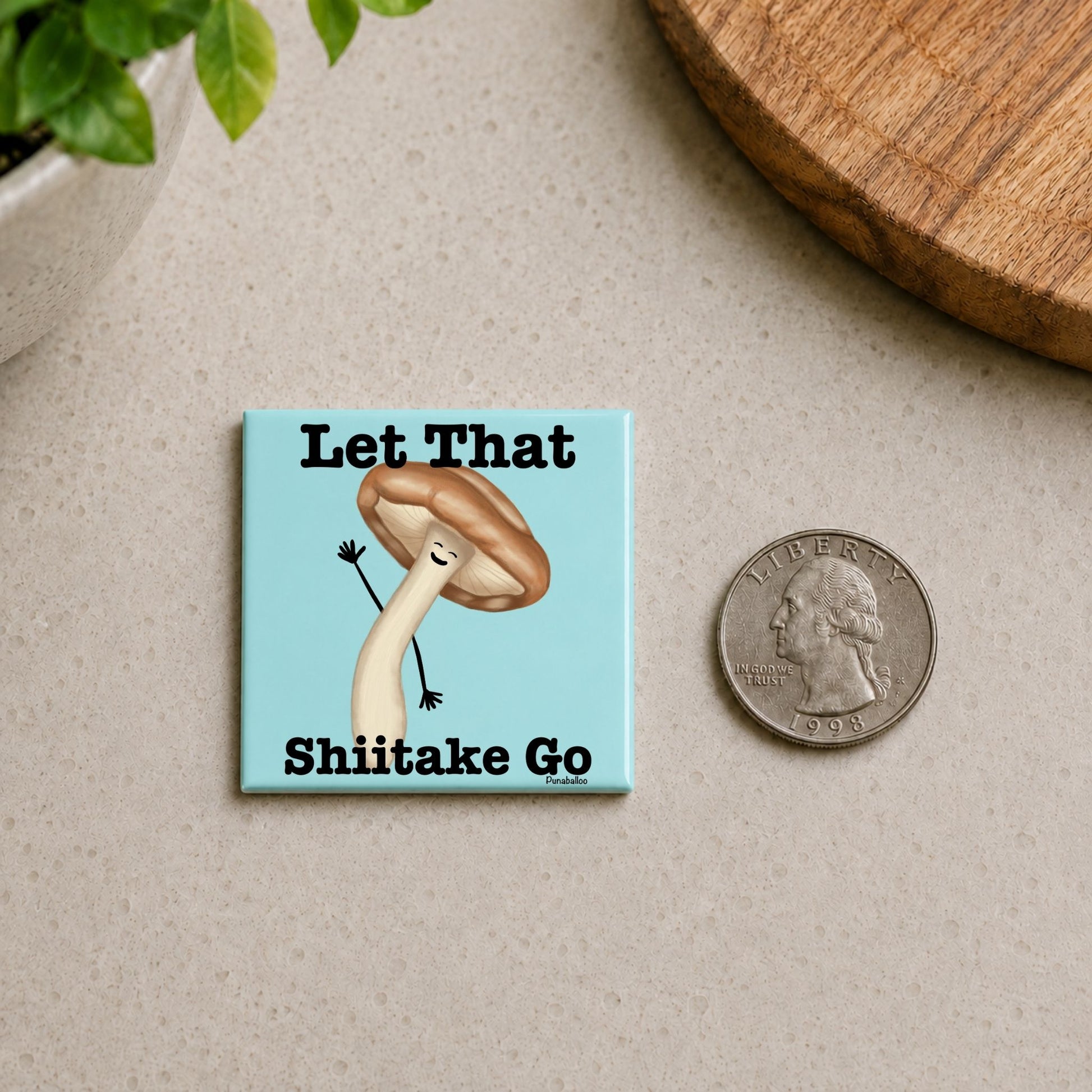 et That Shiitake Go mushroom pun magnet on a countertop beside a quarter for size