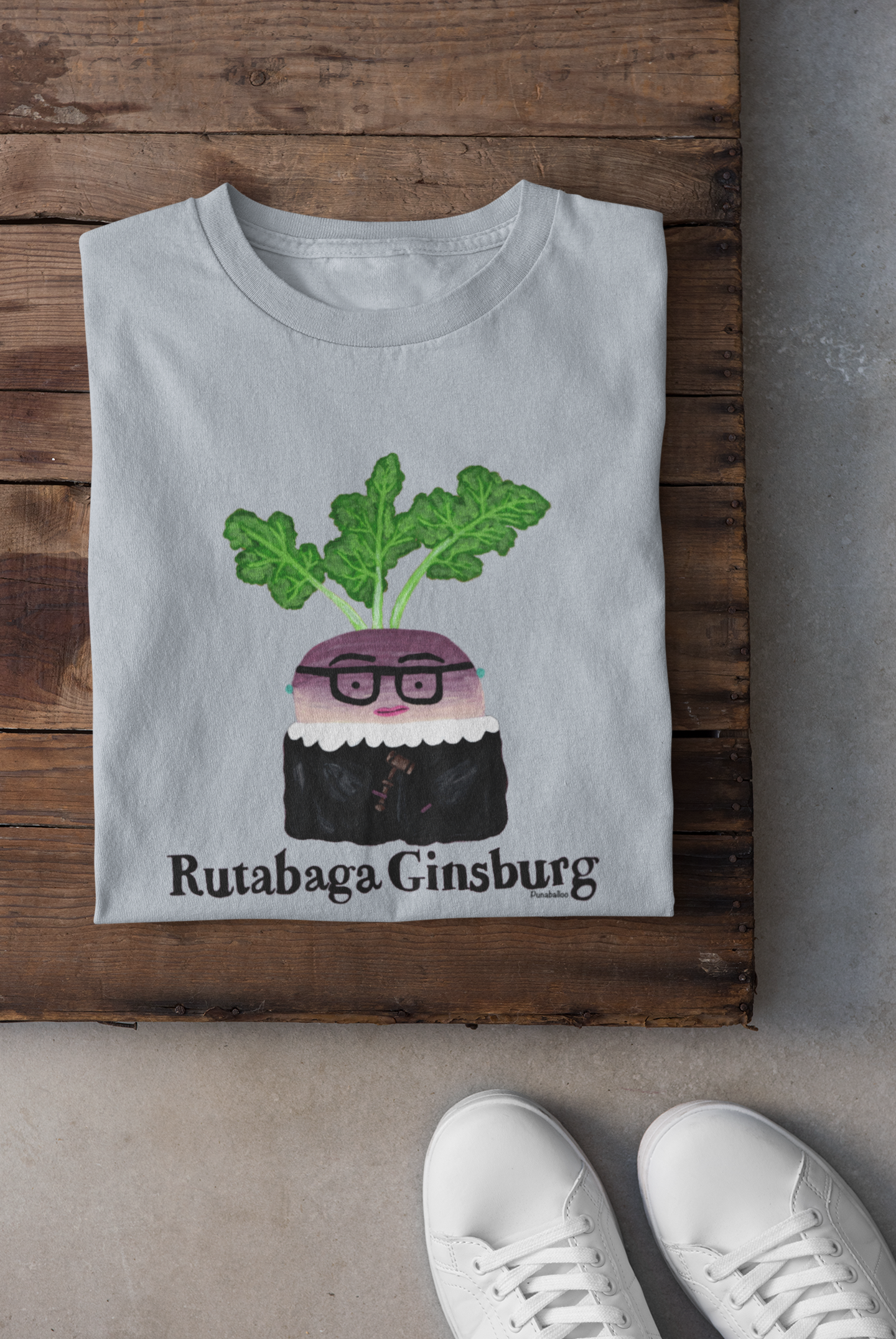 Light blue Rutabaga Ginsburg pun shirt folded with sneakers