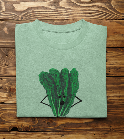 A folded light heather mint t-shirt with Oh Kale No pun printed on the front, displayed flat on a rustic wooden plank background.