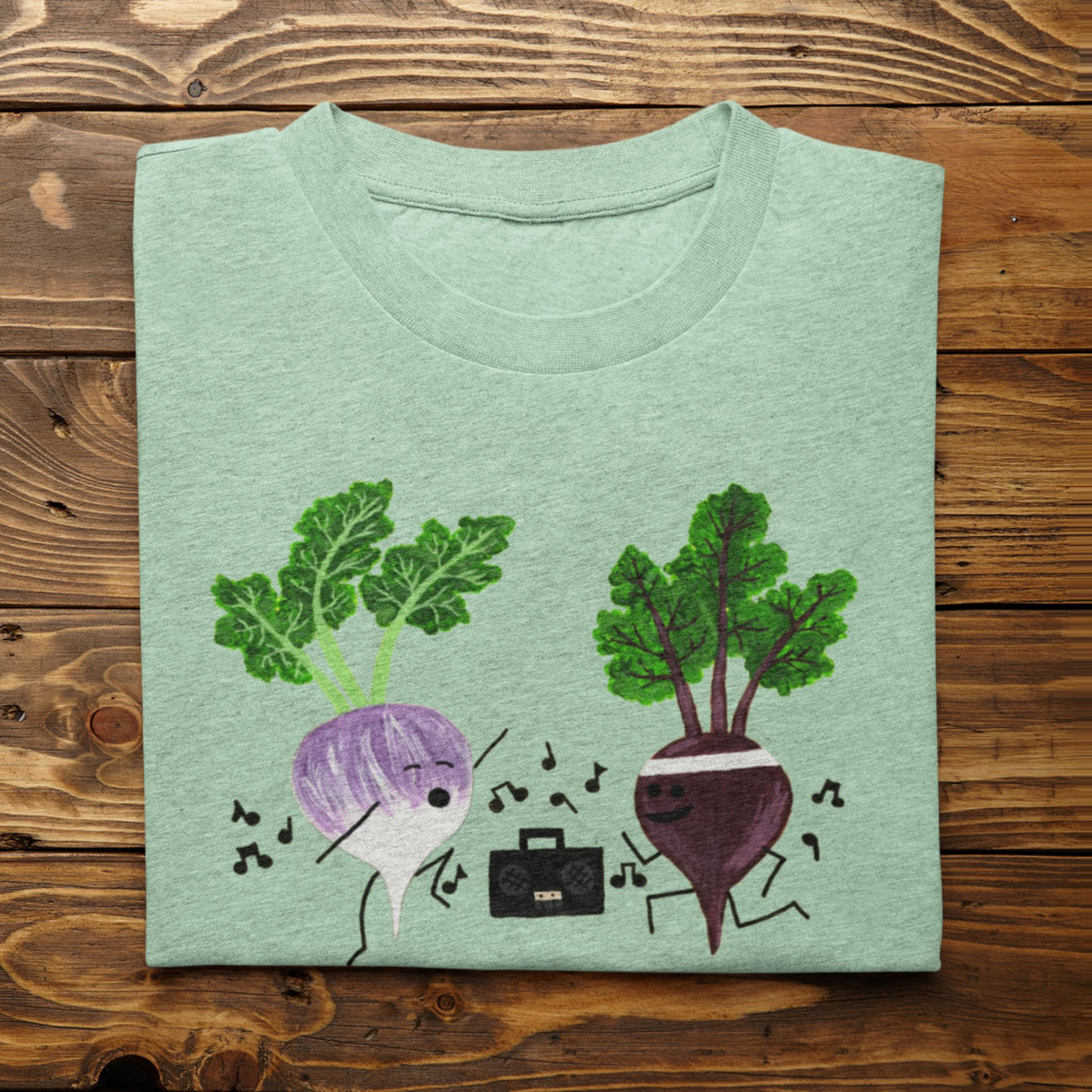 Heather Mint Turnip the Beet vegetable pun T-shirt folded on a rustic wood background