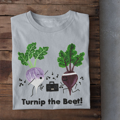 Light Blue Turnip the Beet vegetable pun T-shirt folded on a rustic wood background