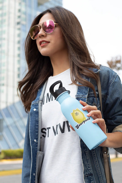 Woman holding a water bottle with Sourpuss lemon pun sticker on a city street
