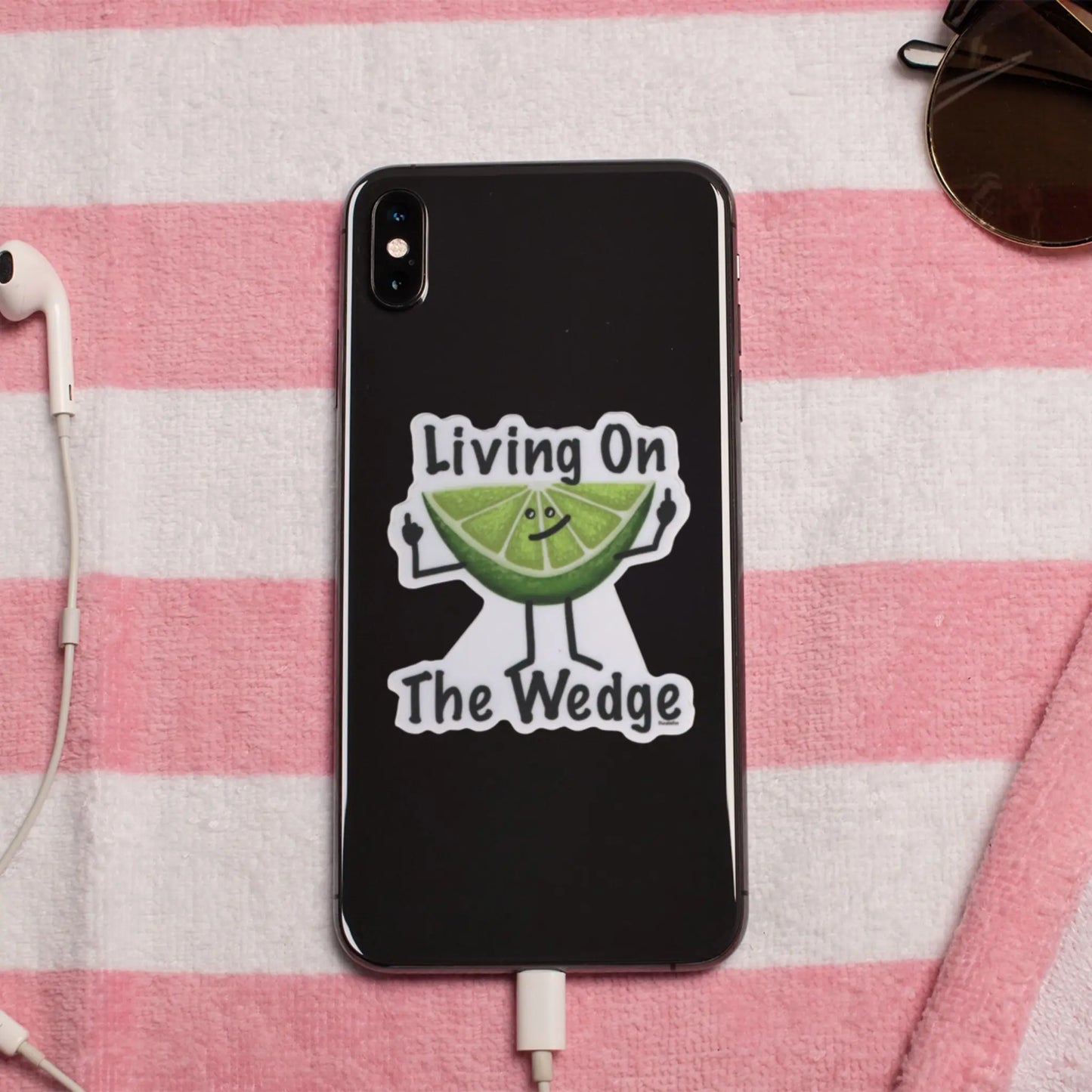 Phone case with 'Living On The Wedge' pun sticker on a pink and white striped towel 