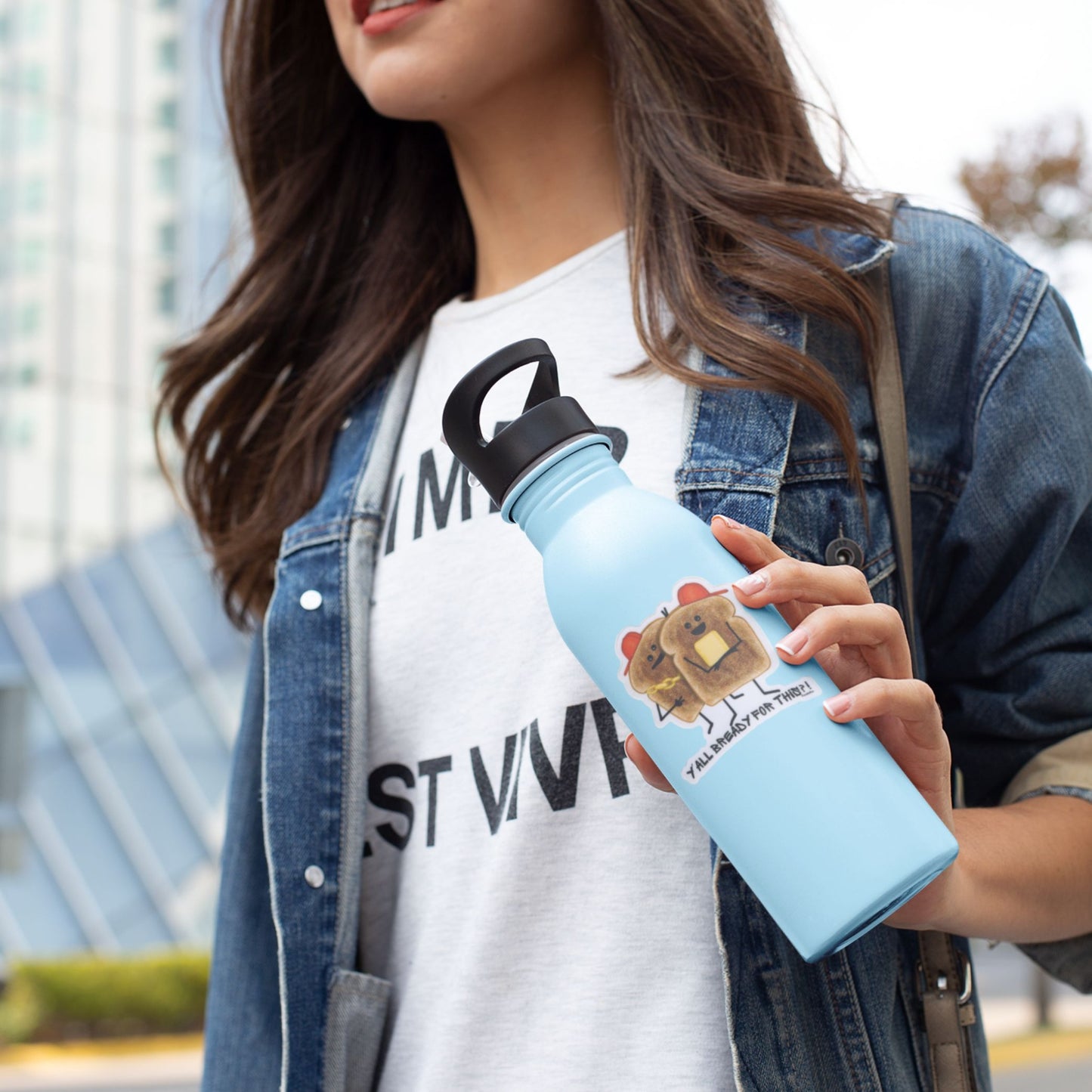 Woman holding a blue water bottle with a Y’all Bready bread sticker
