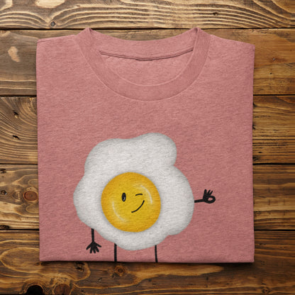 Heather Mauve Yolkie Dokie fried egg pun T-shirt folded on a rustic wood background