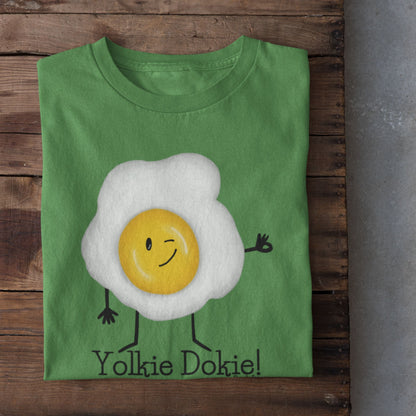 Leaf green Yolkie Dokie fried egg pun T-shirt folded on a rustic wood background